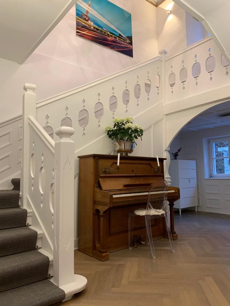 Bezugsfertiges Zuhause, fertiggestellter Wohnbereich mit weißer Treppe und Fischgrät-Parkett